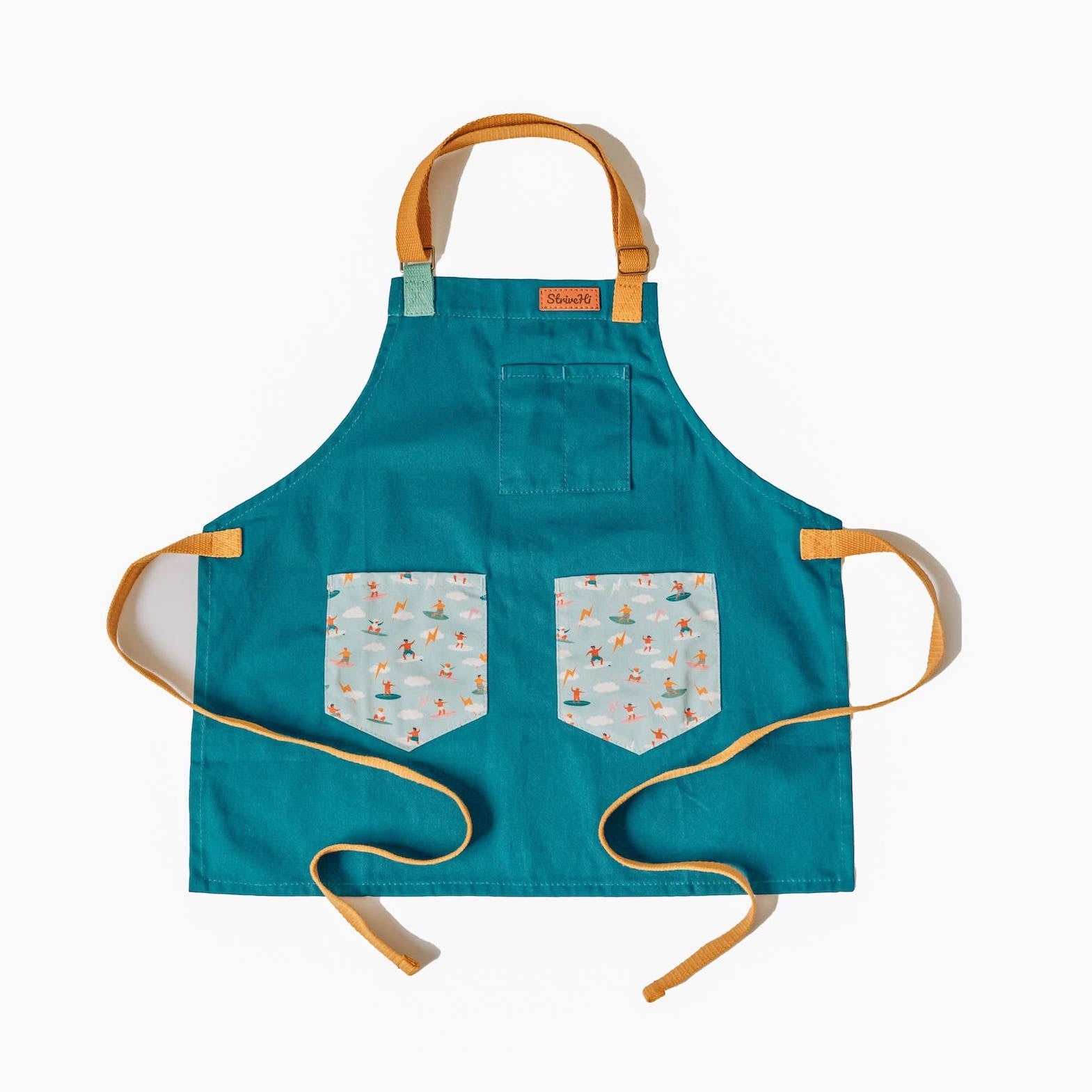 Sturdy children's cooking apron Kids surf apron Durable child apron Soft fabric apron Leather accent apron Bronze details apron Surf-themed apron Child kitchen apron Beach style apron Eco-friendly kids apron Stylish children's apron Durable apron for kids Kids cooking apron Leather strap apron Ocean design apron