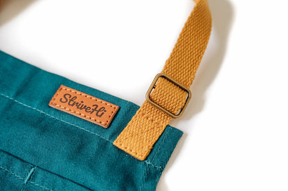 Kids surf apron Durable child apron Soft fabric apron Leather accent apron Bronze details apron Surf-themed apron Child kitchen apron Beach style apron Eco-friendly kids apron Stylish children's apron Durable apron for kids Kids cooking apron Leather strap apron Ocean design apron