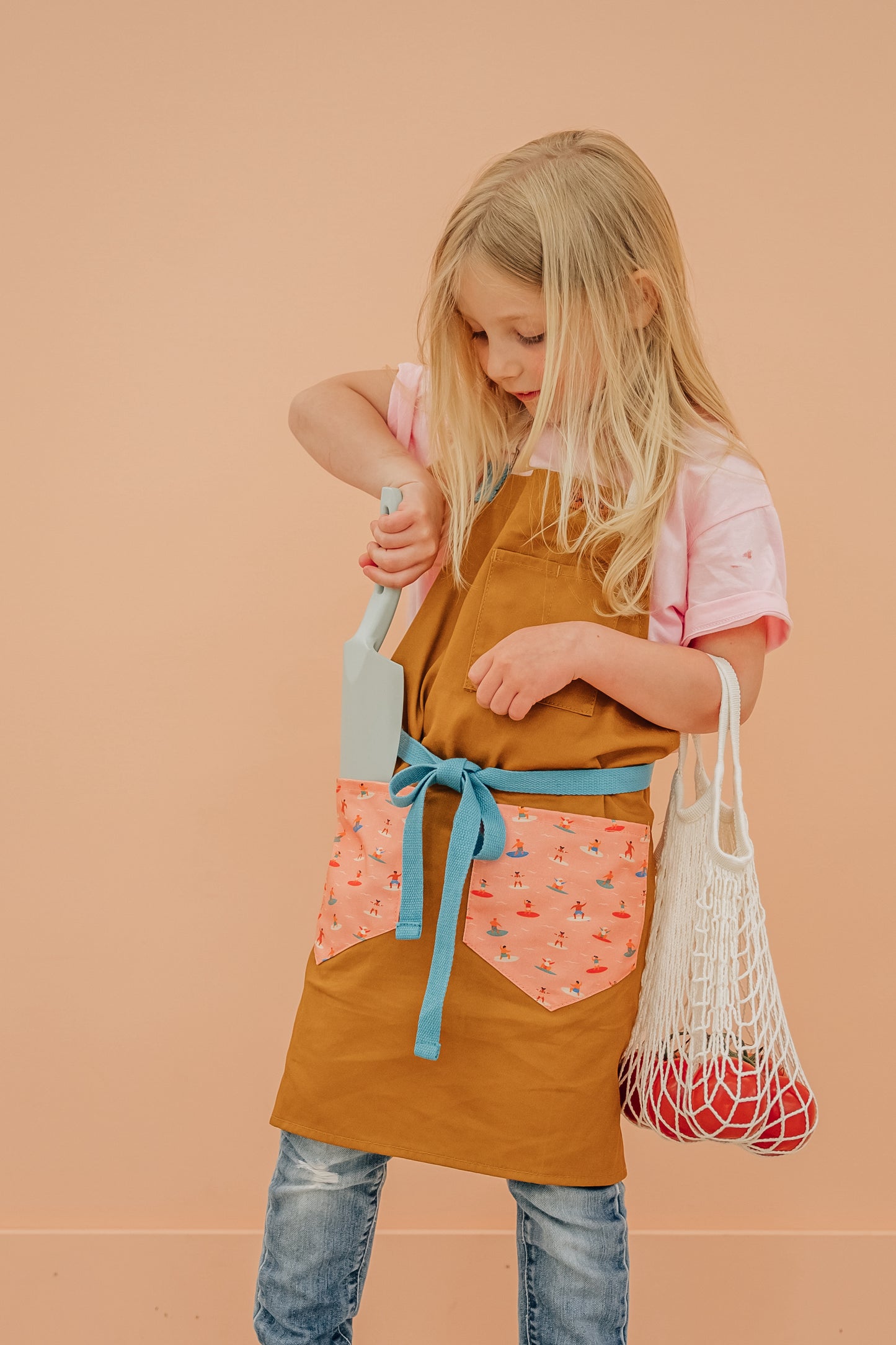 Child surf design apron Durable kids apron Soft fabric child apron Kids apron with leather accents Bronze detailed child apron Surf-themed children's apron Kids kitchen apron durable Leather strap kids apron Ocean design child apron Sturdy kids cooking apron Child apron with bronze accents High-quality kids apron Beach style children’s apron Kid-friendly surf apron
