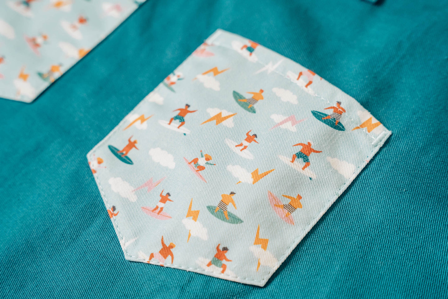 Kids surf apron Durable child apron Soft fabric apron Leather accent apron Bronze details apron Surf-themed apron Child kitchen apron Beach style apron Eco-friendly kids apron Stylish children's apron Durable apron for kids Kids cooking apron Leather strap apron Ocean design apron