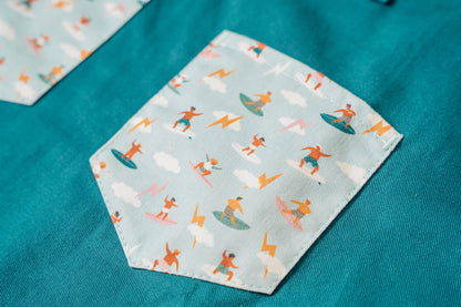 Kids surf apron Durable child apron Soft fabric apron Leather accent apron Bronze details apron Surf-themed apron Child kitchen apron Beach style apron Eco-friendly kids apron Stylish children's apron Durable apron for kids Kids cooking apron Leather strap apron Ocean design apron