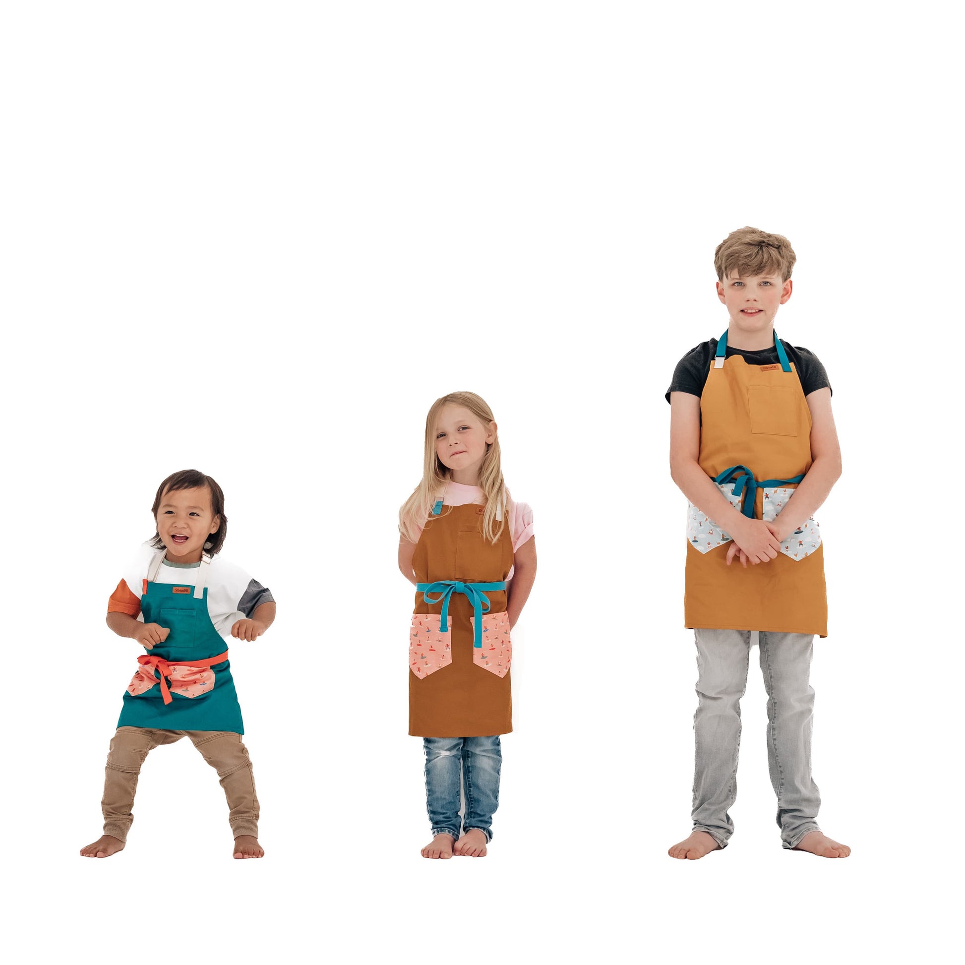 Sturdy children's cooking apron Kids surf apron Durable child apron Soft fabric apron Leather accent apron Bronze details apron Surf-themed apron Child kitchen apron Beach style apron Eco-friendly kids apron Stylish children's apron Durable apron for kids Kids cooking apron Leather strap apron Ocean design apron